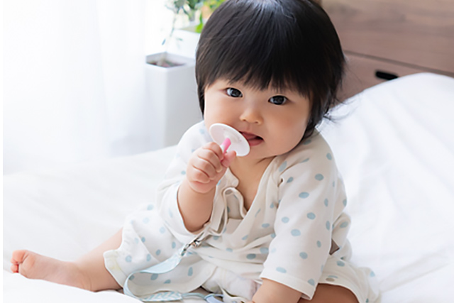 乳歯ブラシを手に持ち噛む赤ちゃん